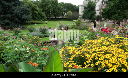 Personnes se détendant dans les jardins du Temple intérieur près des lits de fleurs avec des fleurs jaunes et des plantes de canca en été à Londres, Angleterre, Royaume-Uni KATHY DEWITT Banque D'Images