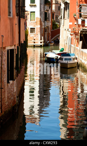 Venise, vue d'un canal pittoresque avec maisons reflet dans l'eau et ses bateaux amarrés Banque D'Images