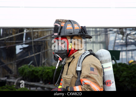 Un pompier sur les lieux d'un incendie dans une serre Banque D'Images