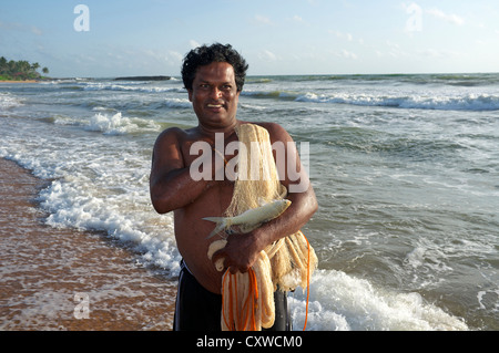 Le pêcheur local à l'aide d'un jet net pour attraper des poissons dans l'Océan Indien au large de la côte à Waikkal, Sri Lanka Banque D'Images