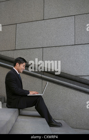 Businessman using laptop sur city Banque D'Images