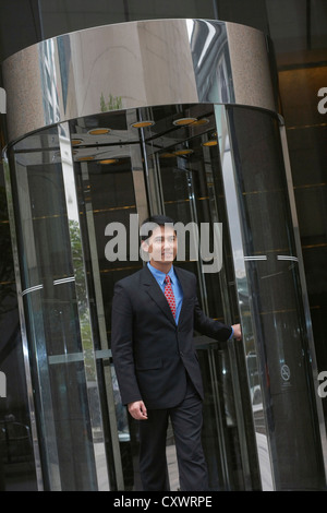 Businessman sortant porte à tambour Banque D'Images