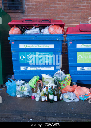 Bac de recyclage pour le verre mélangé trop remplis et avec des bouteilles entassées à côté Banque D'Images