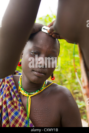 Tribu Suri femme ayant une coupe, Kibish, vallée de l'Omo, Ethiopie Banque D'Images