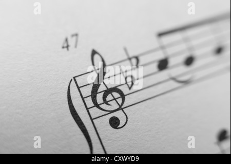 Feuille de score notes de musique mélodie close up noir blanc composition lignes mains gauche droite treble cleft imprimé sur du papier Banque D'Images