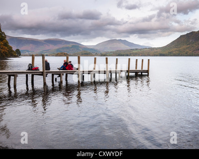 Les marcheurs se reposent sur la jetée par le parc Brandelhow sur Derwent Water près de Keswick, Cumbria, Angleterre. Banque D'Images