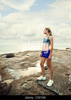 Portrait femme debout sur des rochers près de la plage Banque D'Images