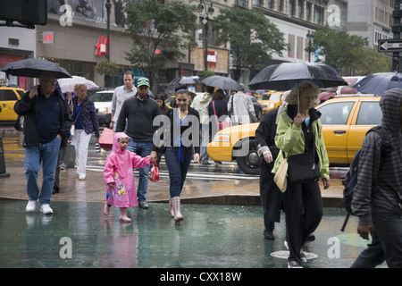 Les piétons traverser le grand carrefour à Broadway par 34e Rue à New York par Herald Square. Banque D'Images