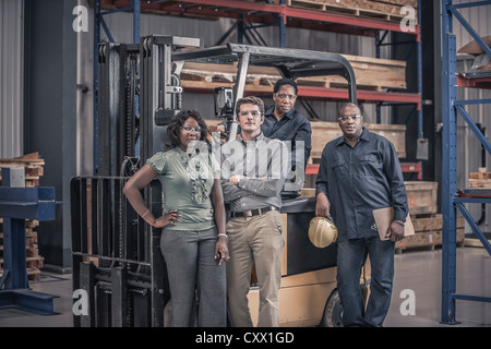 Chariot élévateur avec les travailleurs en usine Banque D'Images