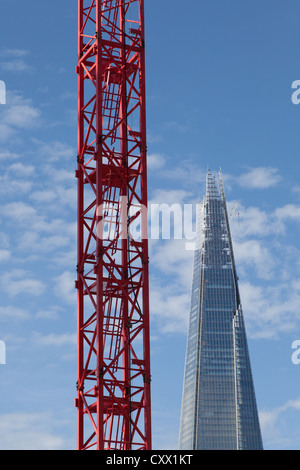 Grue à tour rouge en face de l'Écharde de gratte-ciel de Londres Banque D'Images