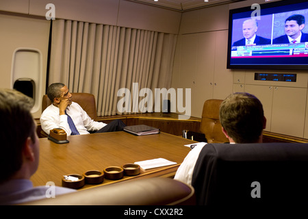 Le président américain Barack Obama regarde le débat à la vice-présidence à bord d'Air Force One avec le personnel le 11 octobre 2012 en route à la maison de la Floride. Banque D'Images