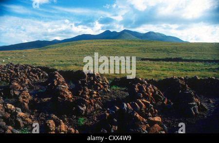 Un paysage de montagne avec coupe de main (tourbe) turl empilés pour le séchage dans le Connemara Galway Irlande Co Banque D'Images