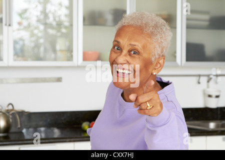 African American Woman pointing in kitchen Banque D'Images