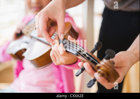 Mixed Race girl apprendre à jouer du violon Banque D'Images