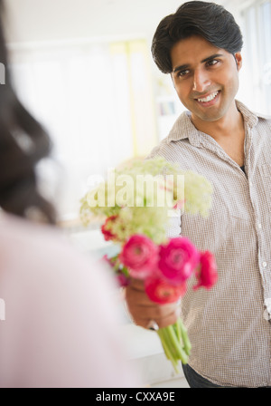 Mixed Race man giving girlfriend fleurs Banque D'Images