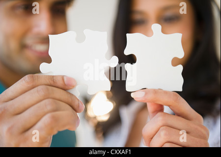 Mixed Race woman holding puzzle pieces Banque D'Images