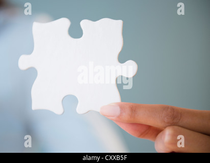 Cape Verdean woman holding morceau de puzzle Banque D'Images