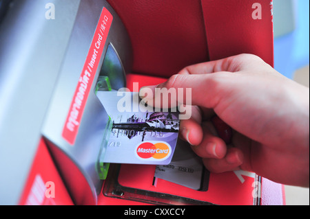 Insère une main de carte en plastique dans l'ATM Banque D'Images