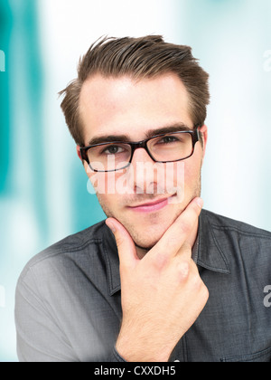 Young businessman wearing glasses, portrait, regard malicieux Banque D'Images