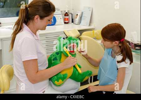 Girl chez le dentiste, de recevoir des instructions pour des soins dentaires sur un modèle, l'hygiène dentaire, les soins dentaires, visite dentaire Banque D'Images