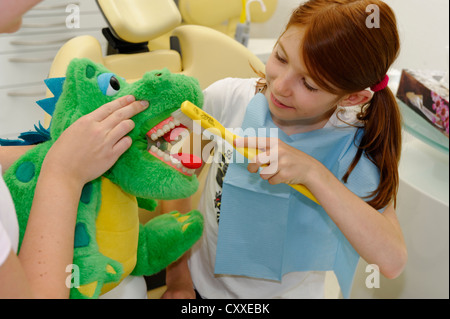 Girl chez le dentiste, de recevoir des instructions pour des soins dentaires sur un modèle, l'hygiène dentaire, les soins dentaires, visite dentaire Banque D'Images