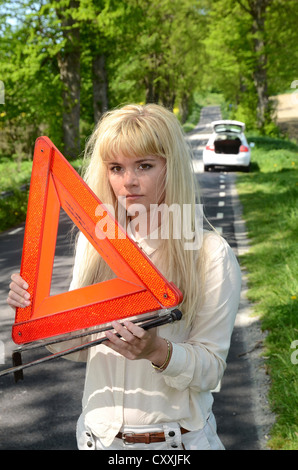 Femme avec triangle de signalisation à une route, Charlottenlund, Skåne, Suède, Europe Banque D'Images