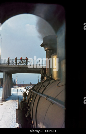 Quatre cyclistes pause dans leur voyage pour admirer le passage du chemin de fer finlandais TK3 Class no1165 construit par A/S Fricus en 1949. Banque D'Images