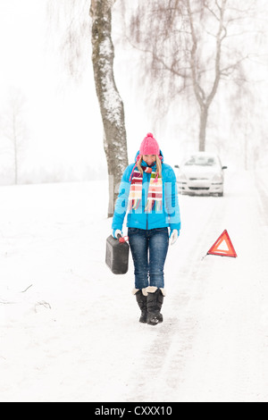 Femme transportant du gaz peut panne de voiture neige hiver balades ventilation Banque D'Images