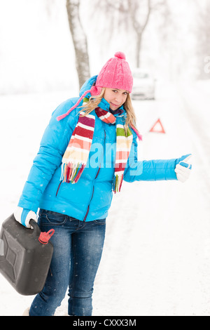 L'auto-stop sur la neige route femme gaz peut panne de voiture problème Banque D'Images