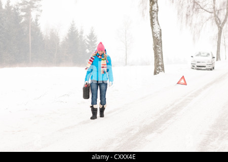 Femme transportant du gaz peut panne de voiture neige hiver balades ventilation Banque D'Images