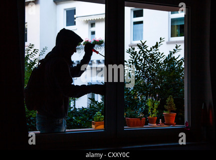 Cambrioleur s'introduit dans un appartement. Image symbole. Banque D'Images