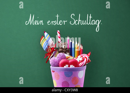 Schultuete ou cône de l'école avec des cadeaux et des bonbons devant une école tableau noir avec le message Mein erster Schultag, Allemand Banque D'Images