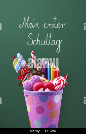 Schultuete ou cône scolaire rempli de cadeaux et de bonbons devant un tableau noir de l'école avec le titre Mein erster Schultag, Banque D'Images