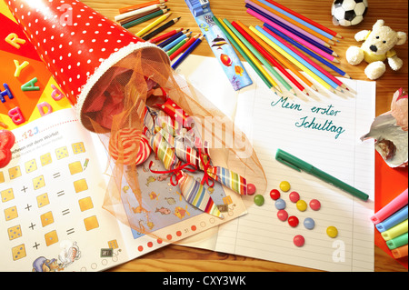 Schultuete ou cône scolaire rempli de cadeaux et de bonbons à côté de crayons de couleur et un ordinateur portable avec le titre Mein erster Banque D'Images