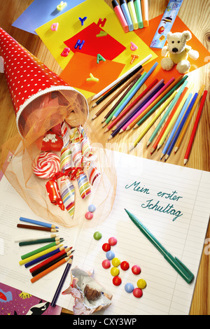 Schultuete ou cône scolaire rempli de cadeaux et de bonbons à côté de crayons de couleur et un ordinateur portable avec le titre Mein erster Banque D'Images