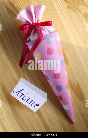 Schultuete ou cône rose école rempli de cadeaux et de bonbons à côté d'une étiquette-nom pour Ariane Banque D'Images
