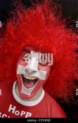 Jeune homme, fan de football avec un visage peint, drapeau national suisse, portant un t-shirt rouge, lettrage "Hopp Schwiiz" Banque D'Images