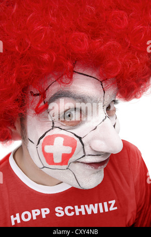 Jeune homme, fan de football avec un visage peint, drapeau national suisse, portant un t-shirt rouge, lettrage "Hopp Schwiiz" Banque D'Images