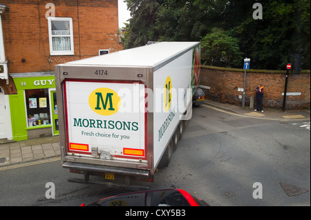 Un camion de livraison Morrisons négocier un virage serré dans une petite ville anglaise Banque D'Images