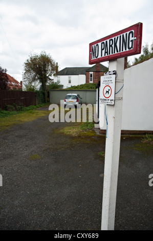 No Parking sign avec voiture en stationnement en arrière-plan Banque D'Images