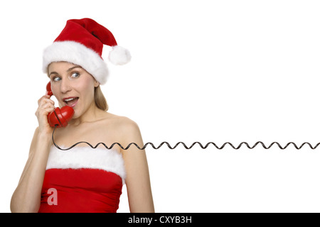 Woman wearing a Santa Claus hat robe et conversation sur un téléphone Banque D'Images