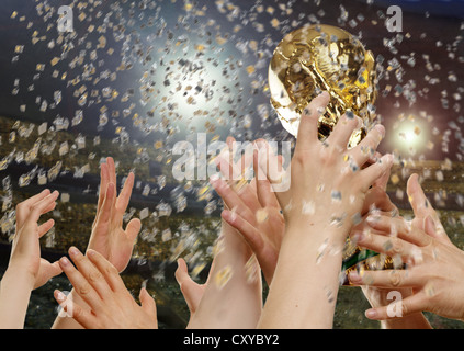 Coupe du Monde de football, tenant la main d'un trophée avec confetti Banque D'Images