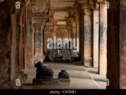 Groupe d'hommes assis en cercle au milieu d'une coupe dans la roche dans le couloir de Temple Brihadishwara, Thanjavur, Inde Banque D'Images