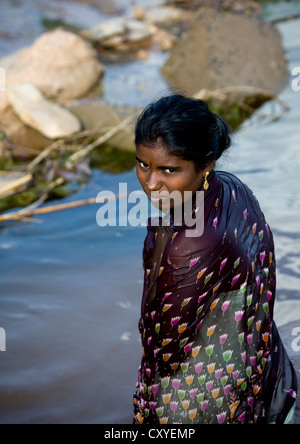 Jeune femme trempée avec poils foncés et les yeux hors de l'eau dans un village près de Madurai, Inde Banque D'Images