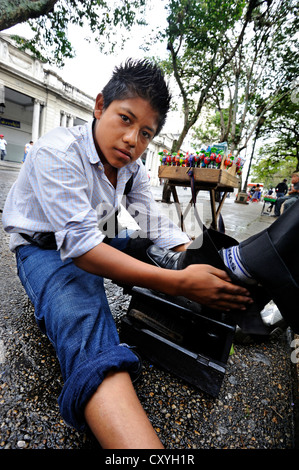 Le travail des enfants, service de cireur garçon, 13 ans, Parque Central, la ville de Guatemala, Guatemala, Amérique Centrale Banque D'Images