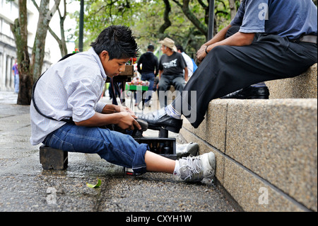 Le travail des enfants, service de cireur garçon, 13 ans, Parque Central, la ville de Guatemala, Guatemala, Amérique Centrale Banque D'Images