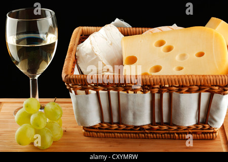 Vin blanc dans un verre avec du fromage et du raisin Banque D'Images