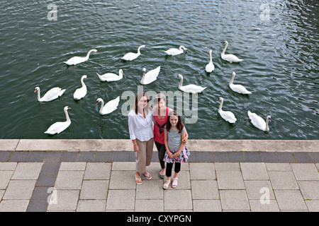 Portrait de mère et deux filles en face de cygnes en marina Banque D'Images