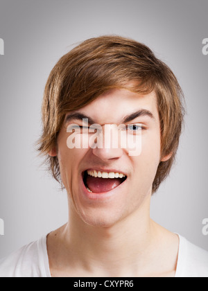 Portrait d'un beau jeune homme, sur un fond gris Banque D'Images