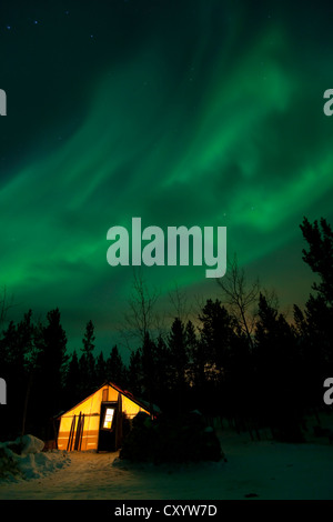 Allumé Allumé, wall tente, cabine avec lumières polaires du nord tourbillonnante, Aurora Borealis, vert, près de Whitehorse, Territoire du Yukon Banque D'Images